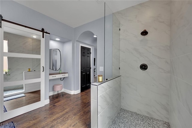 bathroom featuring a walk in shower, wood finished floors, baseboards, and recessed lighting