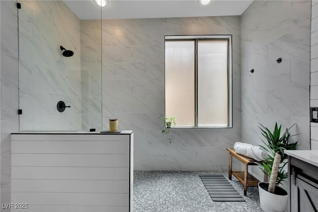 bathroom featuring walk in shower, tile walls, tile patterned flooring, and vanity