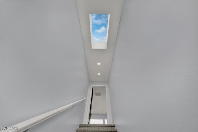 stairs with recessed lighting and a skylight