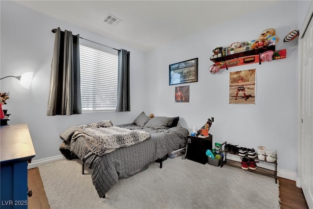 bedroom with wood finished floors and baseboards