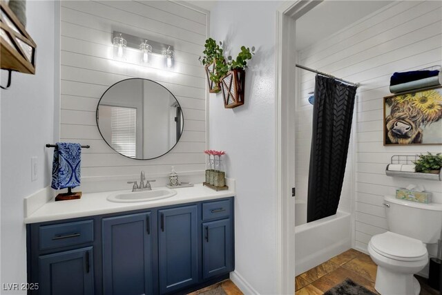 full bath featuring toilet, vanity, shower / bath combo with shower curtain, and stone finish flooring