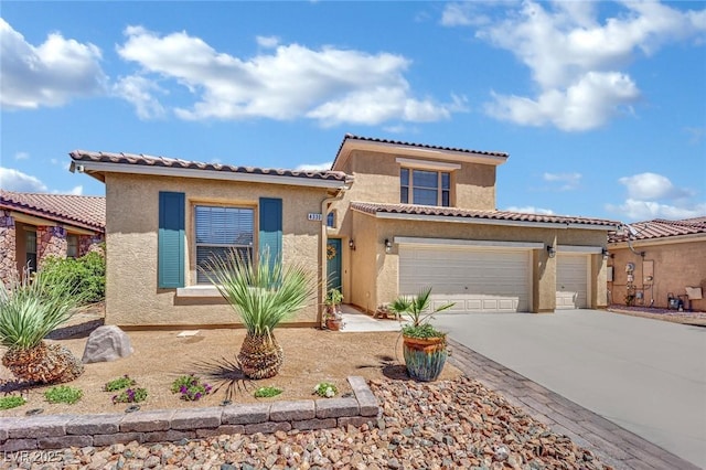mediterranean / spanish-style house with driveway, stucco siding, a tile roof, and an attached garage