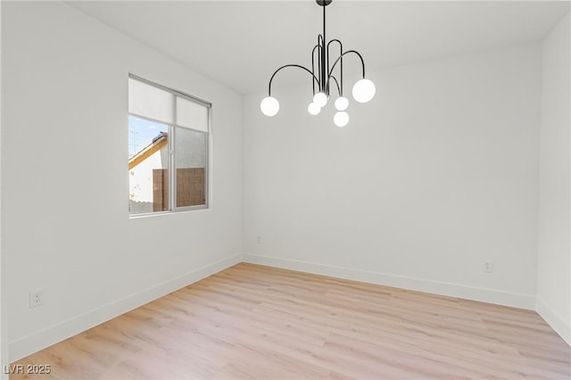 10851 Hanwicke Harbor Ave, Las Vegas, NV 89166 - empty room featuring light wood finished floors, a chandelier, and baseboards