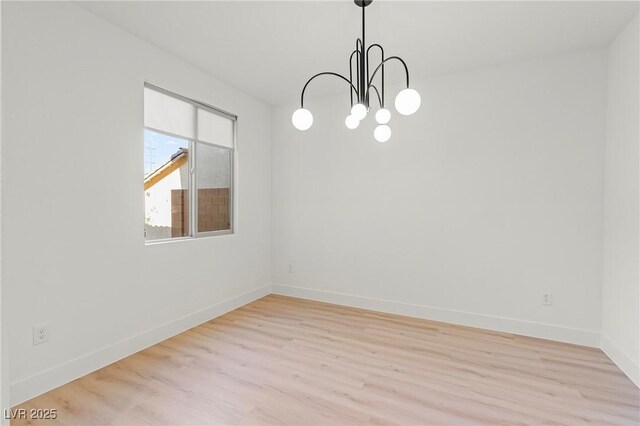 10851 Hanwicke Harbor Ave, Las Vegas, NV 89166 - empty room featuring light wood-style flooring and a chandelier