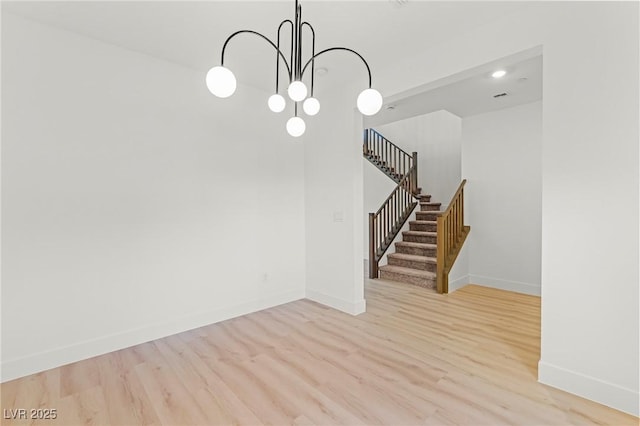 10851 Hanwicke Harbor Ave, Las Vegas, NV 89166 - unfurnished dining area featuring stairway, wood finished floors, a chandelier, and baseboards