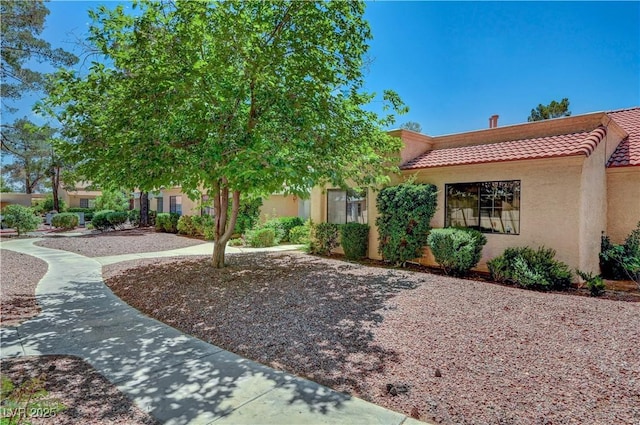 view of front of house featuring a tiled roof and stucco siding
