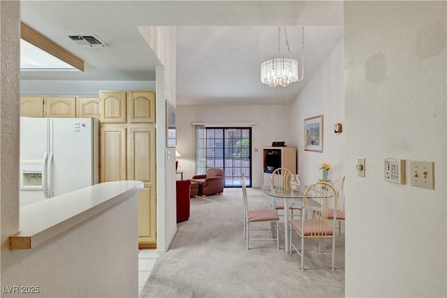 dining space with light colored carpet and a chandelier