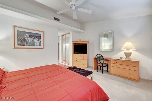 bedroom featuring light colored carpet, a desk, and ceiling fan