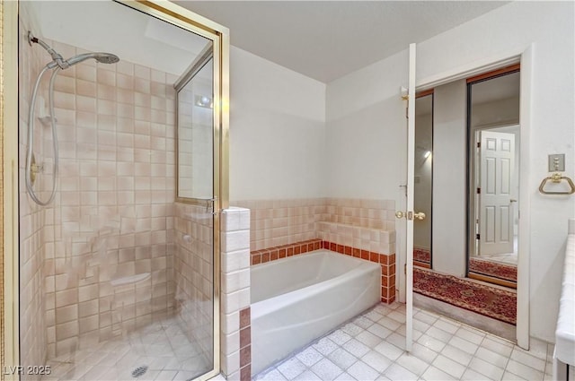full bathroom featuring a stall shower, tile patterned flooring, and a bath
