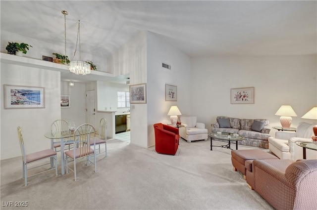 living room with a chandelier, carpet floors, and vaulted ceiling