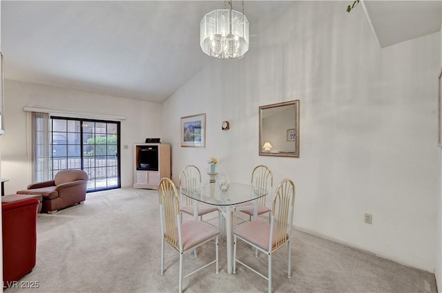 dining room with light colored carpet, a chandelier, and high vaulted ceiling