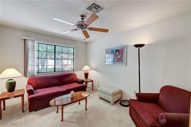 living area with carpet floors, a ceiling fan, and baseboards