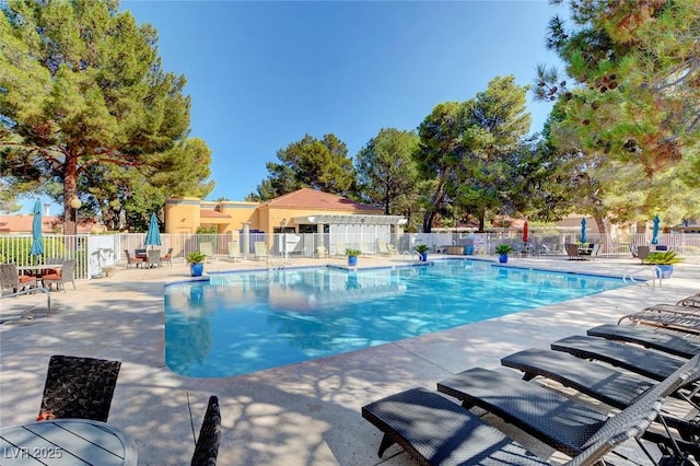 community pool with fence and a patio area