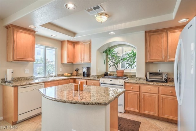 6559 Musette Ave, Las Vegas, NV 89139 - kitchen featuring white appliances, a raised ceiling, a center island, light stone countertops, and recessed lighting
