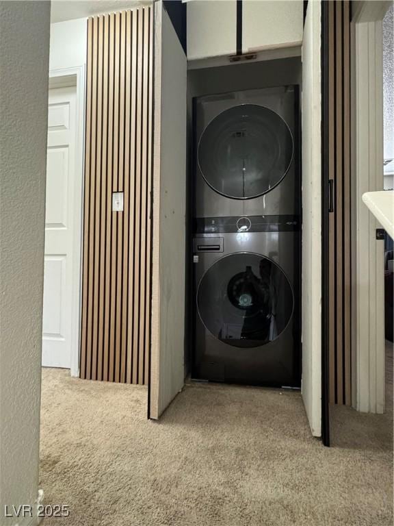 laundry room with stacked washer and clothes dryer and carpet floors