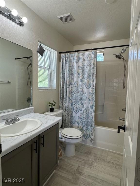 full bath featuring plenty of natural light, a textured ceiling, toilet, shower / bath combination with curtain, and vanity