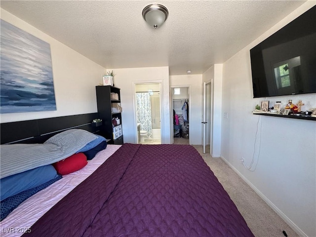 bedroom featuring light carpet, a textured ceiling, ensuite bathroom, and baseboards