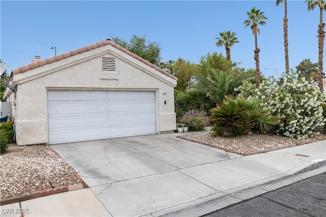 garage featuring concrete driveway