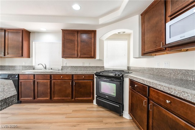 6821 Treble Clef Ave, Las Vegas, NV 89139 - kitchen featuring black appliances, a sink, light wood-style floors, recessed lighting, and a tray ceiling