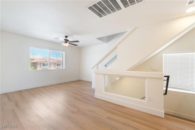 6821 Treble Clef Ave, Las Vegas, NV 89139 - unfurnished living room with light wood-style flooring, ceiling fan, and baseboards
