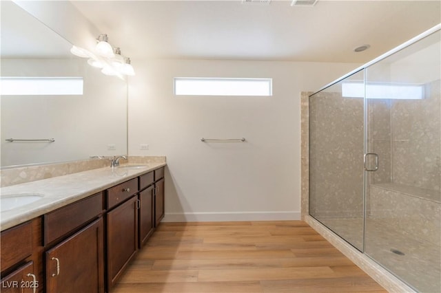 6821 Treble Clef Ave, Las Vegas, NV 89139 - full bathroom with wood finished floors, a stall shower, double vanity, and baseboards
