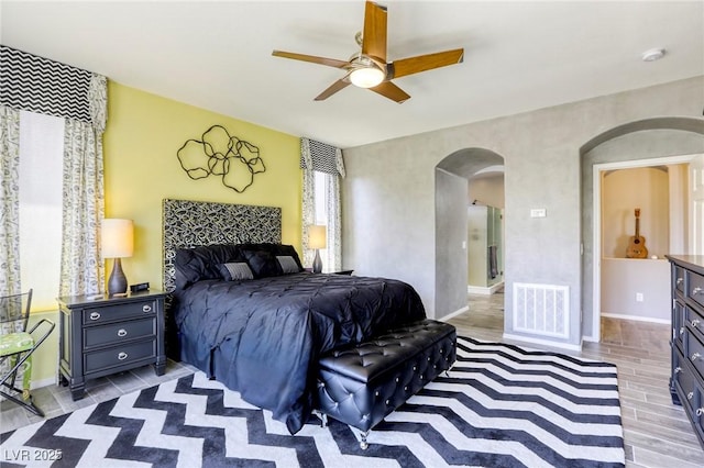 5650 Pleasant Palms St, North Las Vegas, NV 89081 - bedroom featuring arched walkways, baseboards, ceiling fan, and wood finished floors
