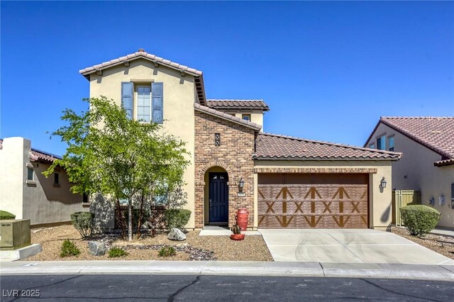 5650 Pleasant Palms St, North Las Vegas, NV 89081 - mediterranean / spanish-style house featuring an attached garage, a tile roof, concrete driveway, stucco siding, and brick siding