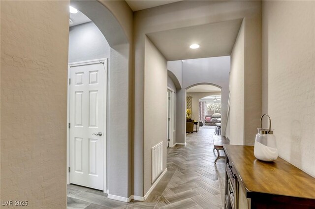 5650 Pleasant Palms St, North Las Vegas, NV 89081 - hall featuring arched walkways, a textured wall, and baseboards
