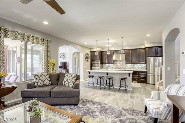 5650 Pleasant Palms St, North Las Vegas, NV 89081 - living room with arched walkways, light wood-type flooring, ceiling fan, recessed lighting, and baseboards