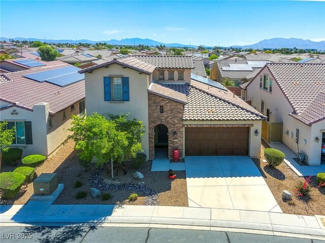 5650 Pleasant Palms St, North Las Vegas, NV 89081 - mediterranean / spanish-style house featuring stucco siding, a tiled roof, a garage, and a residential view