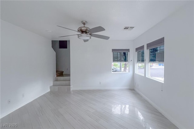 9148 Alluring Ave, Las Vegas, NV 89149 - unfurnished room with a ceiling fan, stairs, baseboards, and light wood-style flooring