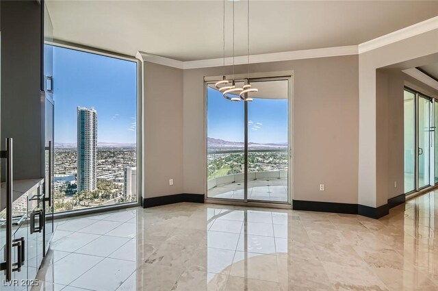 2777 Paradise Rd Unit 2701Ph, Las Vegas, NV 89109 - empty room with a chandelier, a wall of windows, and ornamental molding