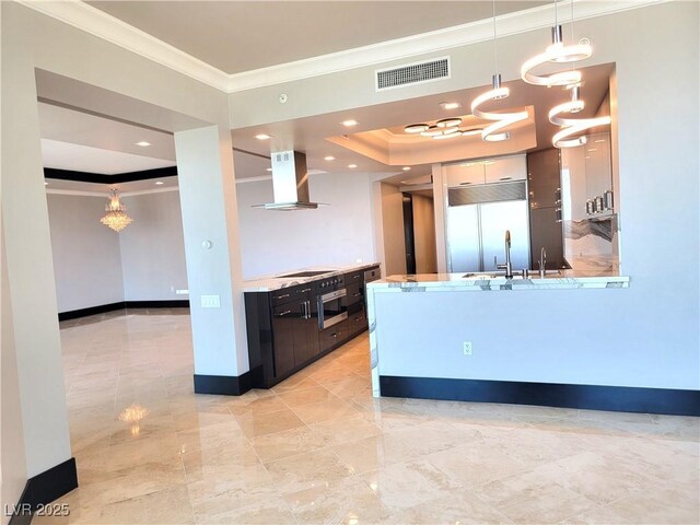 2777 Paradise Rd Unit 2701Ph, Las Vegas, NV 89109 - kitchen with wall chimney range hood, a chandelier, built in fridge, ornamental molding, and a raised ceiling