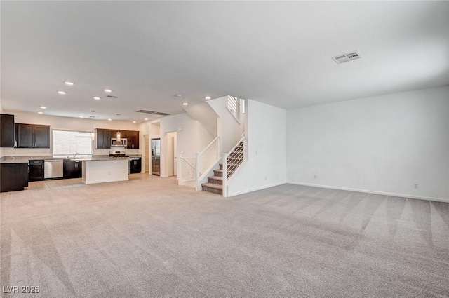 8056 Haywood Estate Ave, Las Vegas, NV 89113 - unfurnished living room with stairs, recessed lighting, light colored carpet, baseboards, and a sink