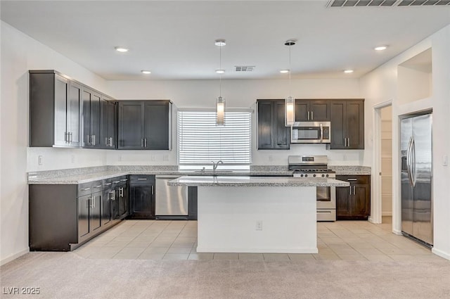 8056 Haywood Estate Ave, Las Vegas, NV 89113 - kitchen featuring appliances with stainless steel finishes, light stone counters, decorative light fixtures, light tile patterned flooring, and a kitchen island