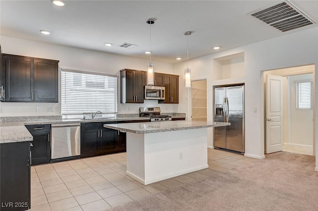 8056 Haywood Estate Ave, Las Vegas, NV 89113 - kitchen with stainless steel appliances, a sink, light tile patterned flooring, pendant lighting, and recessed lighting