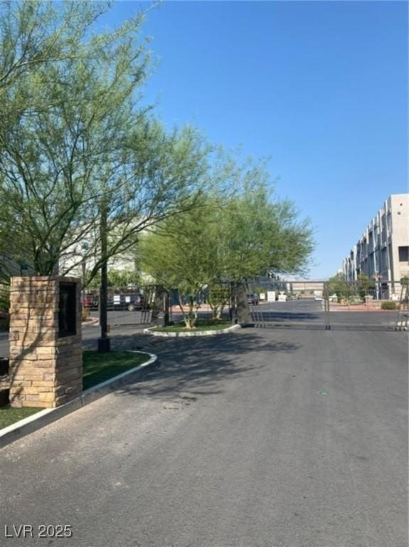 8056 Haywood Estate Ave, Las Vegas, NV 89113 - view of asphalt road with curbs and a gated entry