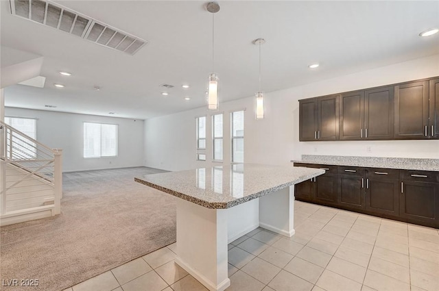 8056 Haywood Estate Ave, Las Vegas, NV 89113 - kitchen featuring light colored carpet, recessed lighting, light tile patterned floors, dark brown cabinetry, and a kitchen island