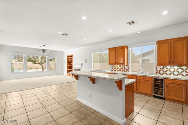 215 Great Gable Dr, Las Vegas, NV 89183 - kitchen featuring beverage cooler, tile countertops, open floor plan, light tile patterned floors, and light colored carpet