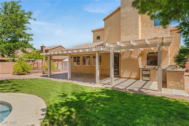 rear view of property with an outdoor kitchen, a pergola, stucco siding, a patio area, and a tile roof