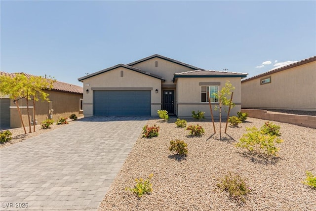 ranch-style home with decorative driveway, a garage, and stucco siding
