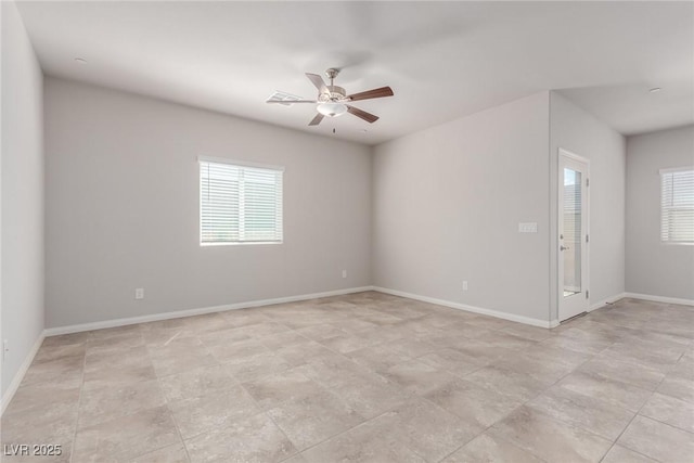 spare room featuring ceiling fan and baseboards