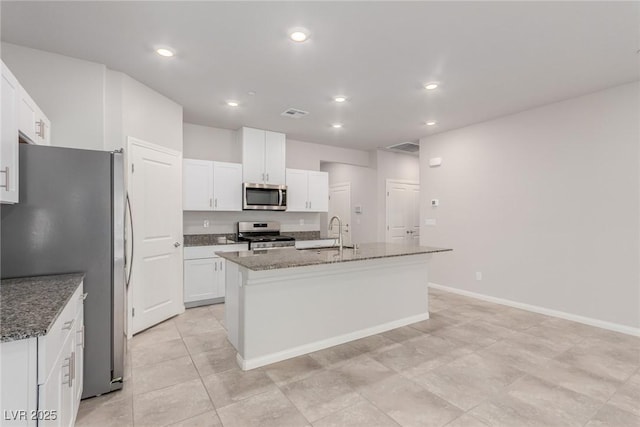 10257 Sequoia Falls Pl, Las Vegas, NV 89149 - kitchen with stainless steel appliances, a sink, an island with sink, white cabinets, and dark stone countertops