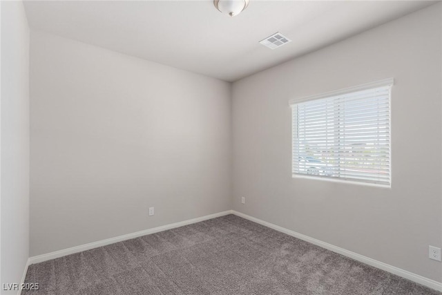 carpeted empty room featuring baseboards