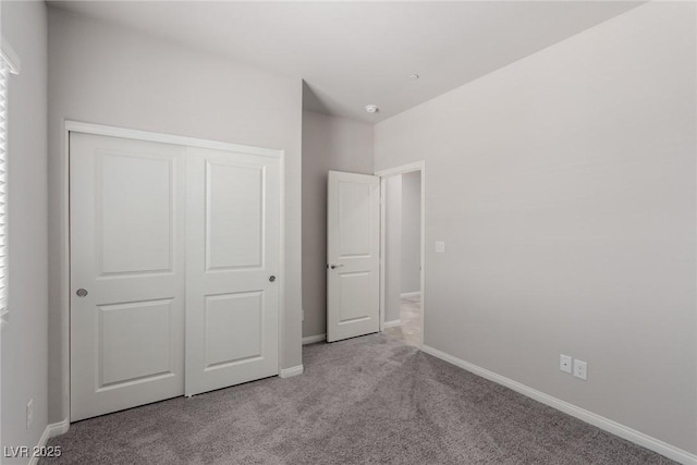 unfurnished bedroom featuring carpet flooring, a closet, and baseboards