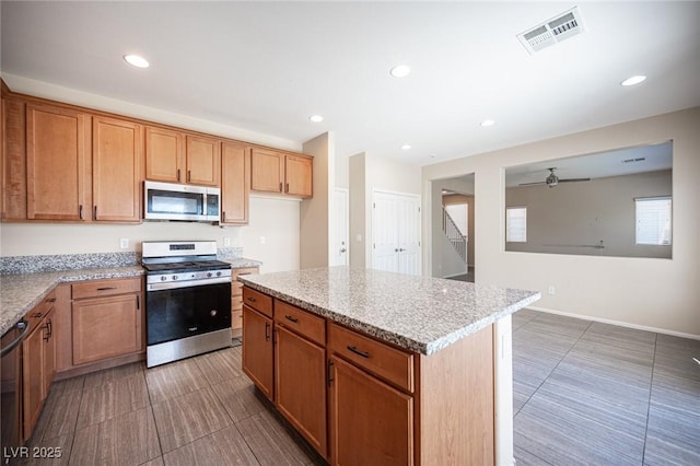 1405 Gilbert Creek Ave, North Las Vegas, NV 89031 - kitchen with stainless steel appliances, a ceiling fan, recessed lighting, a kitchen island, and tile patterned flooring