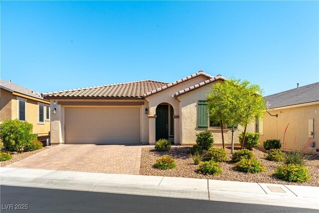 10742 Cowlite Ave, Las Vegas, NV 89166 - mediterranean / spanish-style home featuring stucco siding, a garage, a tiled roof, and decorative driveway