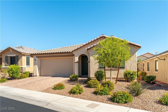 view of front of house featuring a garage, stucco siding, decorative driveway, and a tile roof