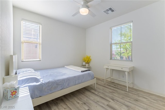 bedroom with wood finished floors, baseboards, and a ceiling fan