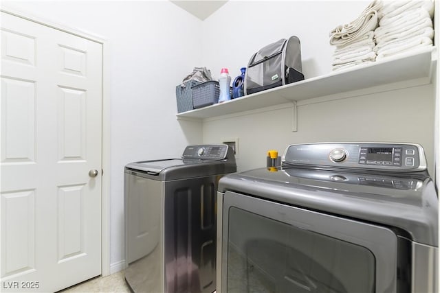 laundry area with separate washer and dryer and light tile patterned floors